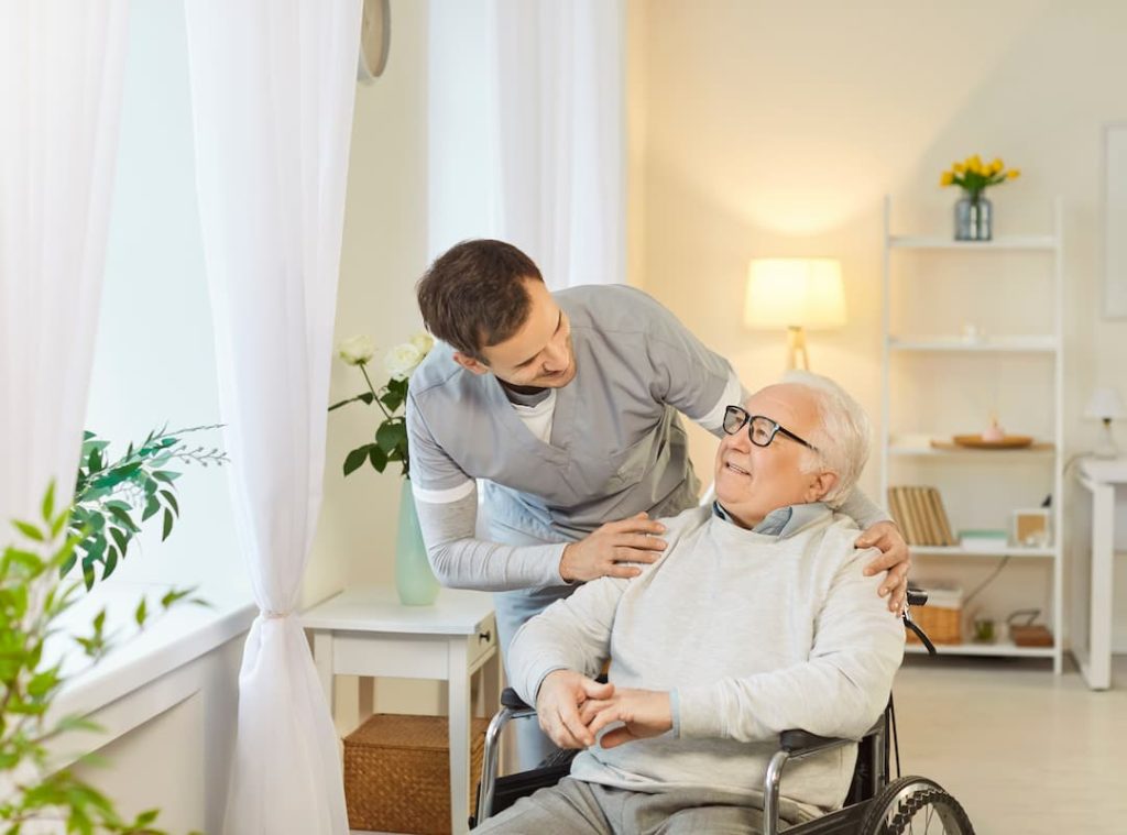 Male nurse providing help to elderly man who is disabled