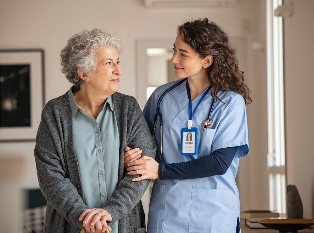 Caregiver assist senior woman at home