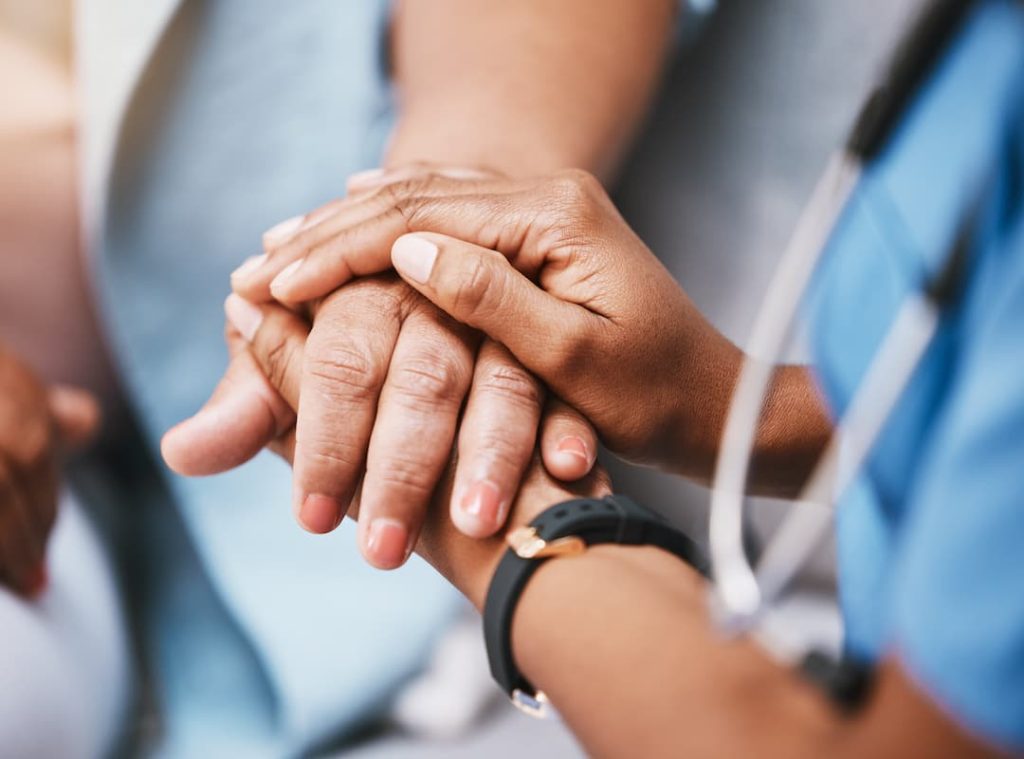 a close-up of a doctor holding a patient's hand