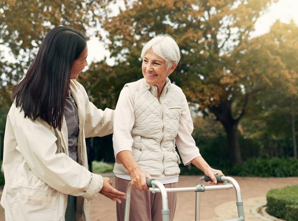 a woman helping an older woman with a walker
