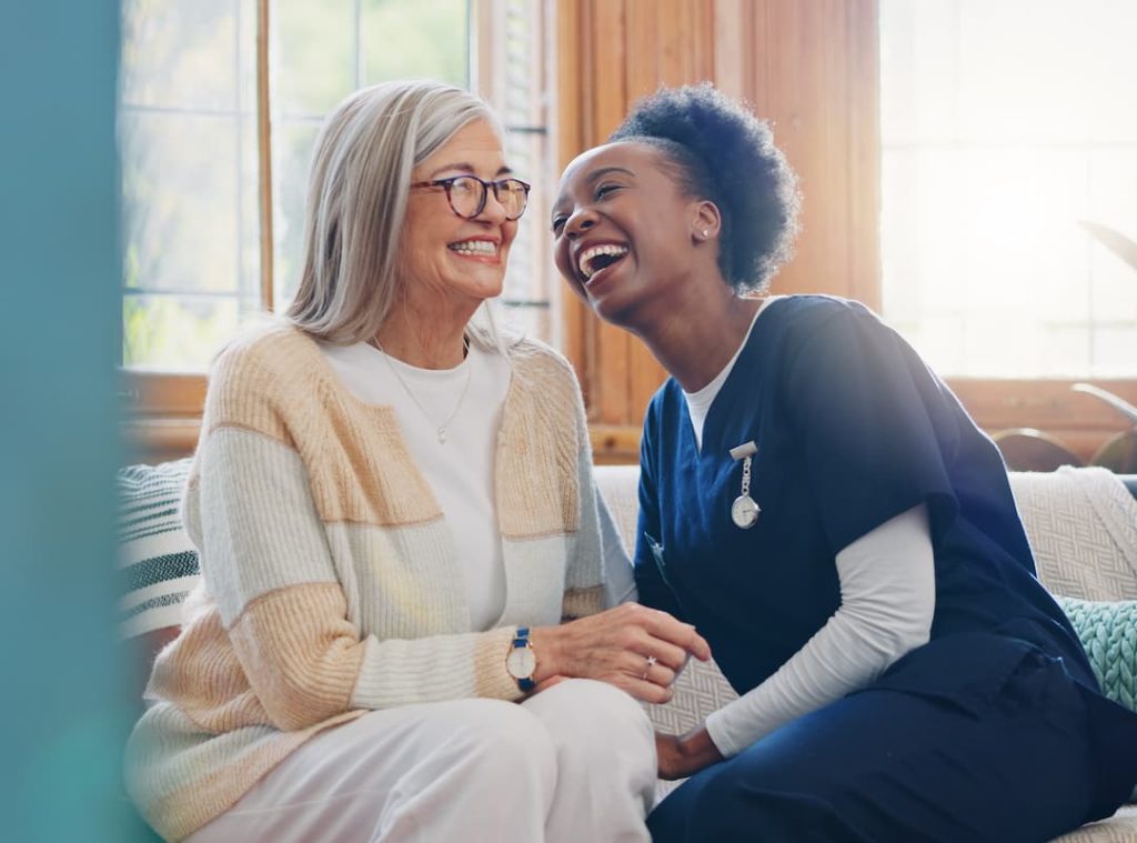 Senior patient, funny or happy caregiver talking for healthcare support at nursing home clinic